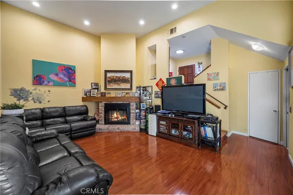 a living room with furniture a flat screen tv and a fireplace