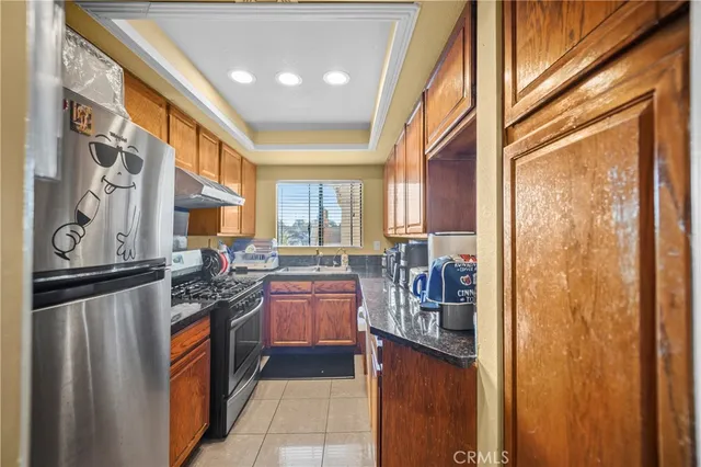 a kitchen with stainless steel appliances granite countertop a refrigerator a stove top oven a sink and dishwasher