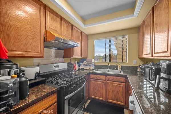 a kitchen with stainless steel appliances granite countertop a stove a sink and a microwave
