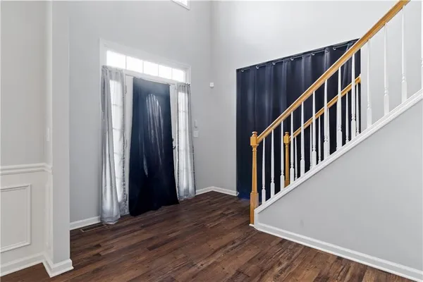a view of a hallway with wooden floor and staircase
