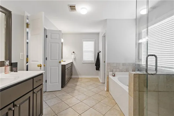 a large bathroom with a tub sink and mirror