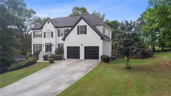 a view of a house with a yard and tree