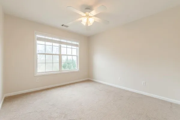 an empty room with a window and a ceiling fan