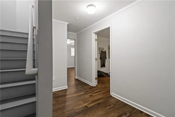 a view of a hallway with wooden floor and entryway