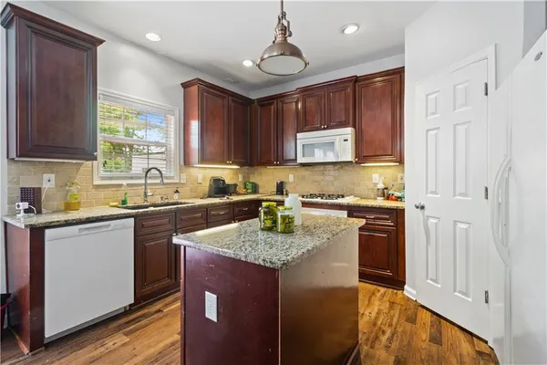 a kitchen with granite countertop a sink stove and cabinets