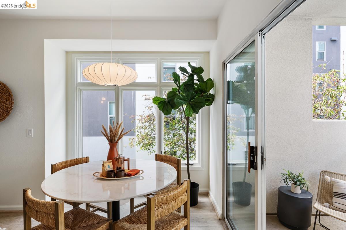 2029 Channing Way, Unit 3D Berkeley, CA 94704 - Photo 13 of 54 Dining area featuring a contemporary pendant light fixture, large multi-pane window, and light wood-finish flooring