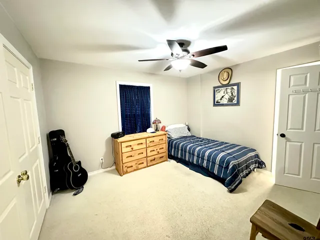 a bedroom with a large bed and a ceiling fan