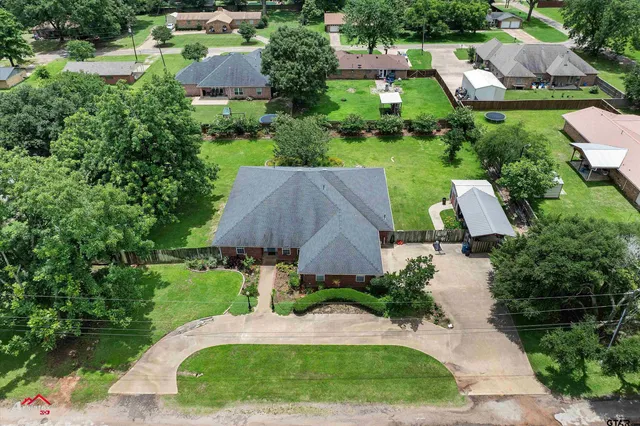 an aerial view of a house with yard and green space