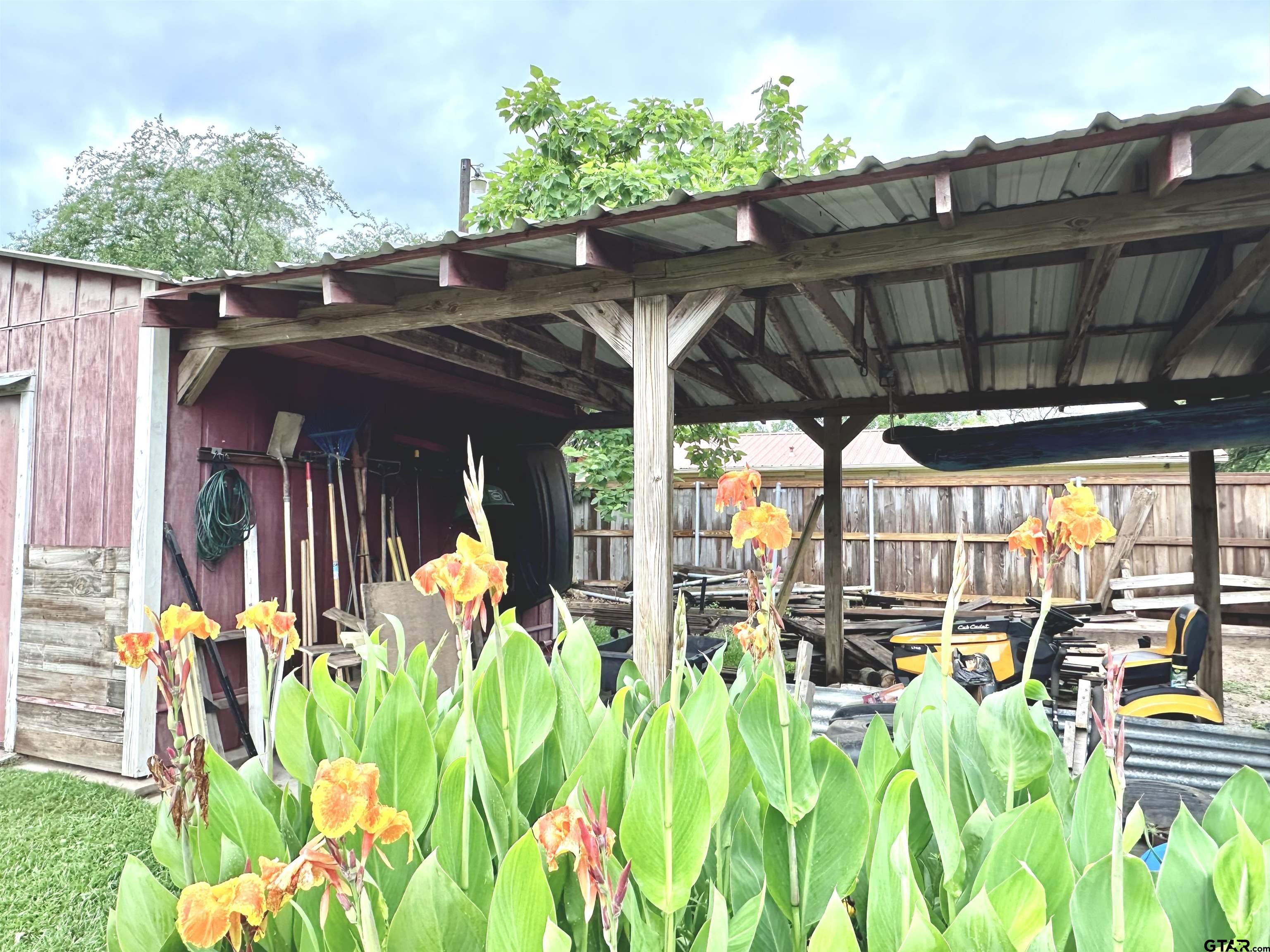 142 Parrish Rusk, TX 75785 - Photo 47 of 48 a view of a patio with table and chairs potted plants and floor to ceiling window and wooden fence