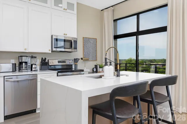 a kitchen with stainless steel appliances a table and chairs