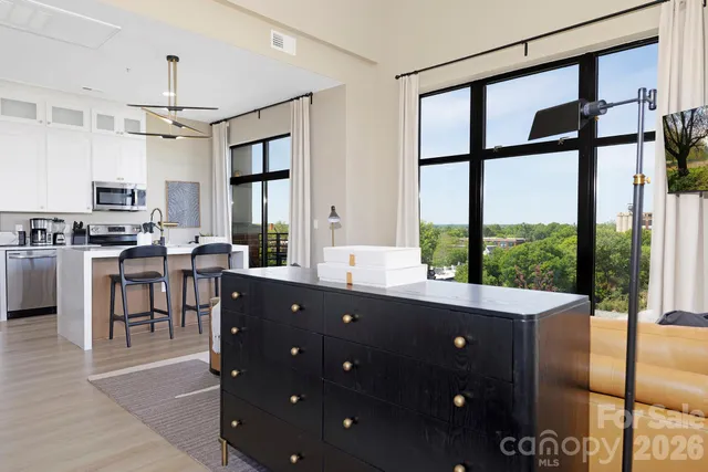 a living room with a large window and stainless steel appliances