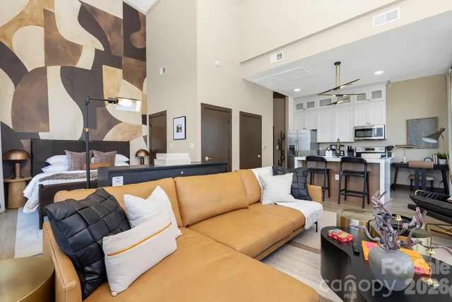 a living room with furniture kitchen view and a chandelier