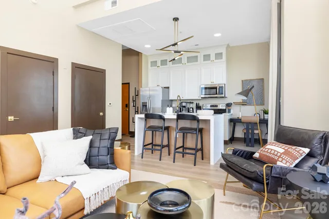 a living room with lots of furniture and kitchen view