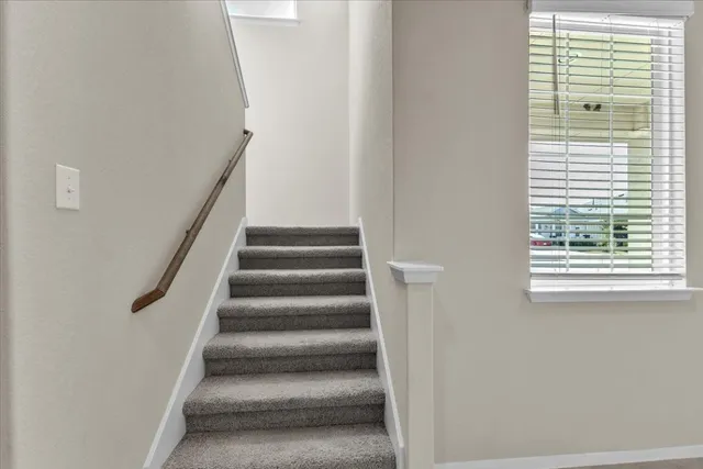 a view of staircase with white walls and a window