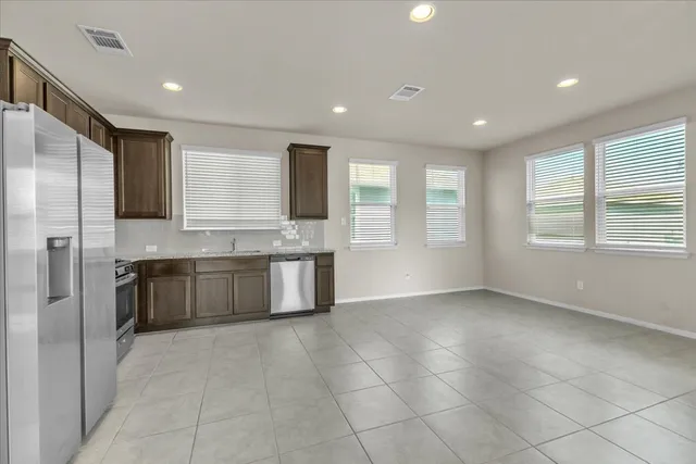 a large kitchen with a large window and stainless steel appliances