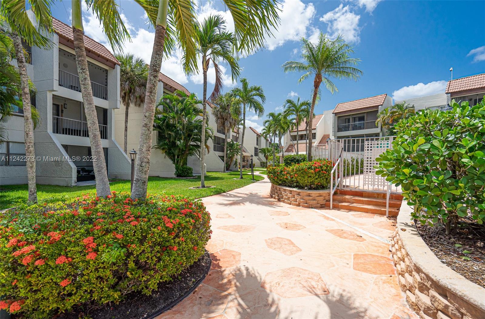 303 Racquet Club Road, Unit 307 Weston, FL 33326 - Photo 1 of 22 a view of a house with a yard and potted plants