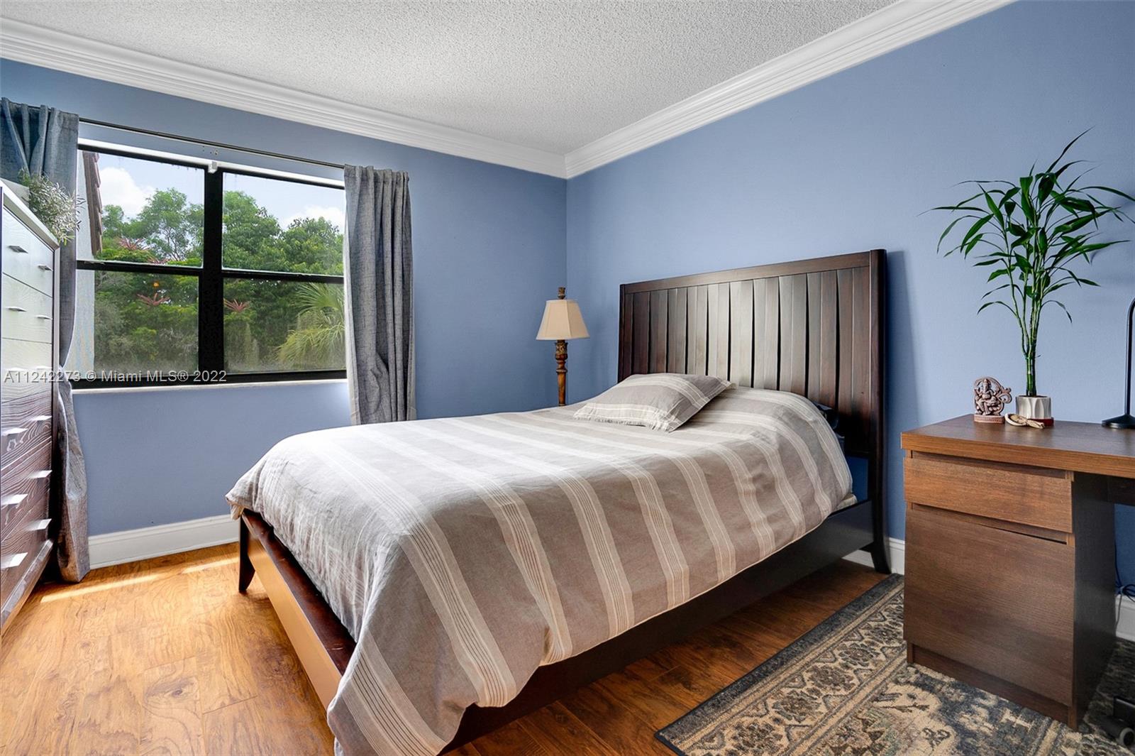 303 Racquet Club Road, Unit 307 Weston, FL 33326 - Photo 16 of 22 a bedroom with a bed and a potted plant