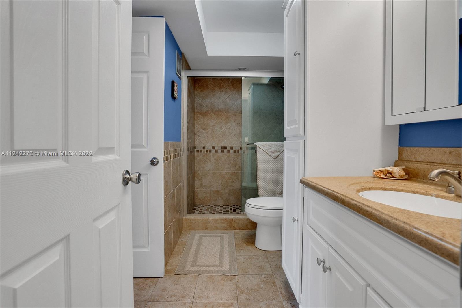 303 Racquet Club Road, Unit 307 Weston, FL 33326 - Photo 17 of 22 a bathroom with a granite countertop sink a toilet and shower