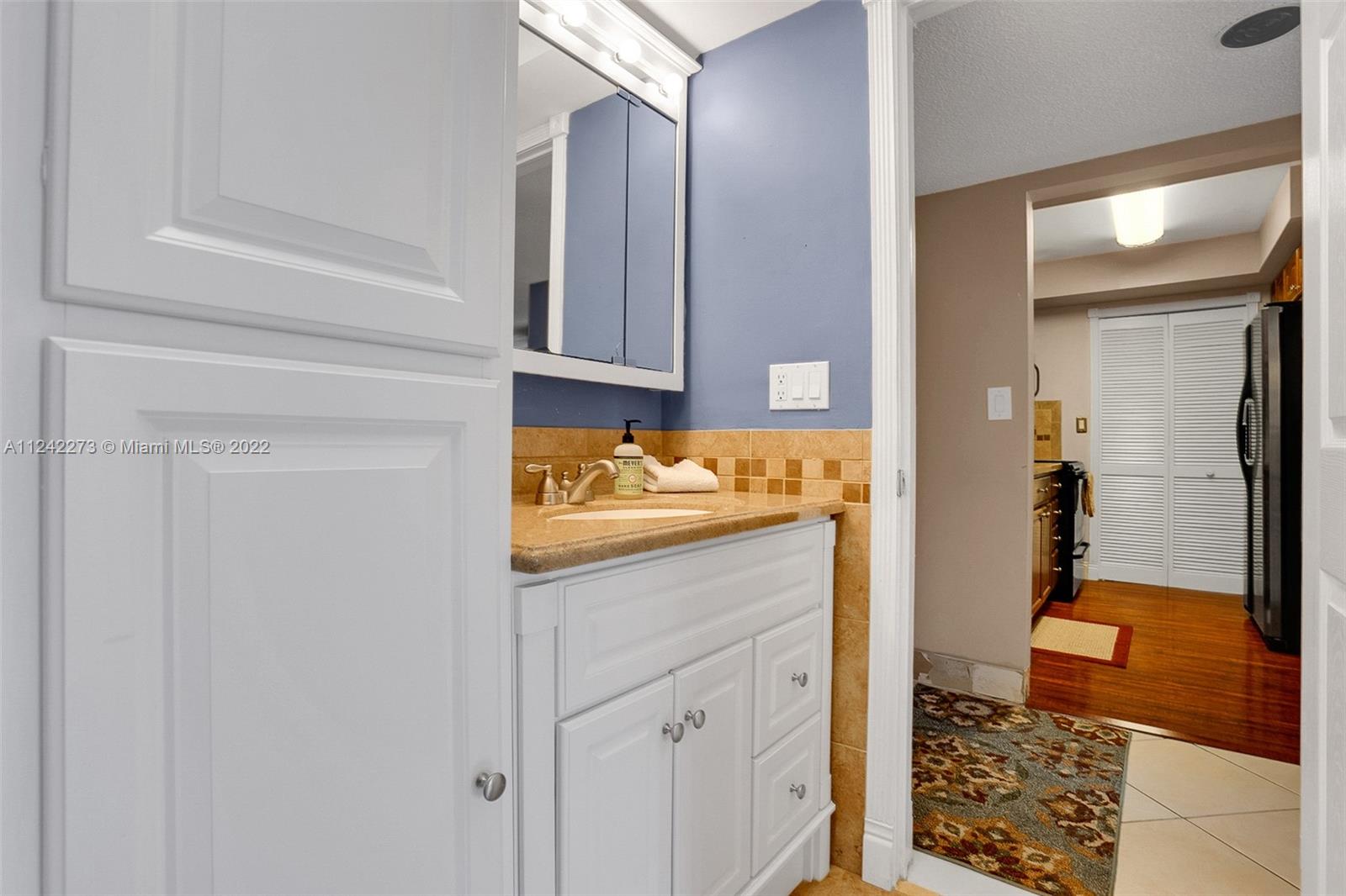 303 Racquet Club Road, Unit 307 Weston, FL 33326 - Photo 18 of 22 a bathroom with a granite countertop sink and a mirror