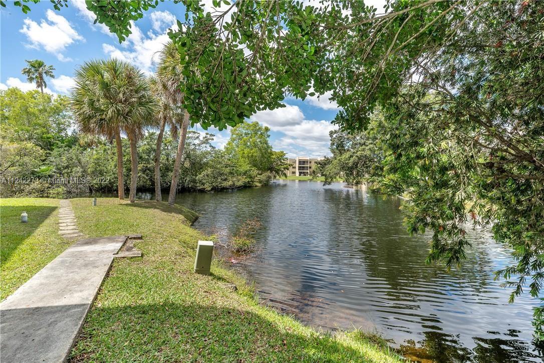 303 Racquet Club Road, Unit 307 Weston, FL 33326 - Photo 3 of 22 a view of a lake from a yard