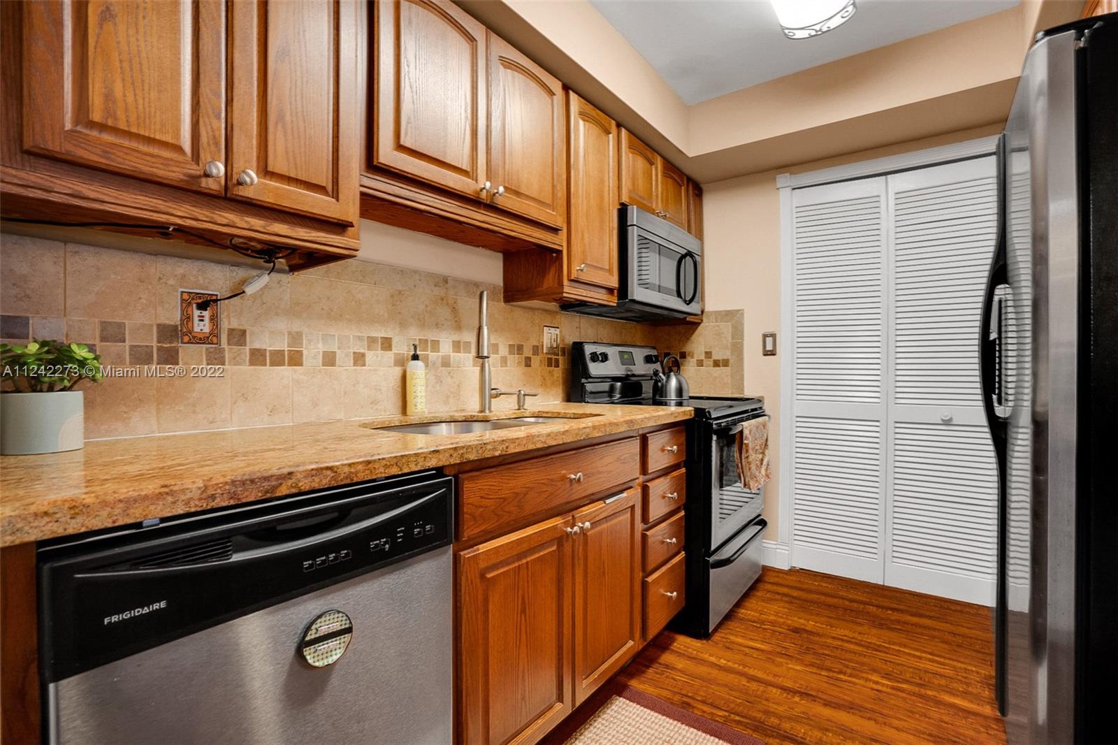 303 Racquet Club Road, Unit 307 Weston, FL 33326 - Photo 5 of 22 a kitchen with stainless steel appliances granite countertop a sink stove and cabinets