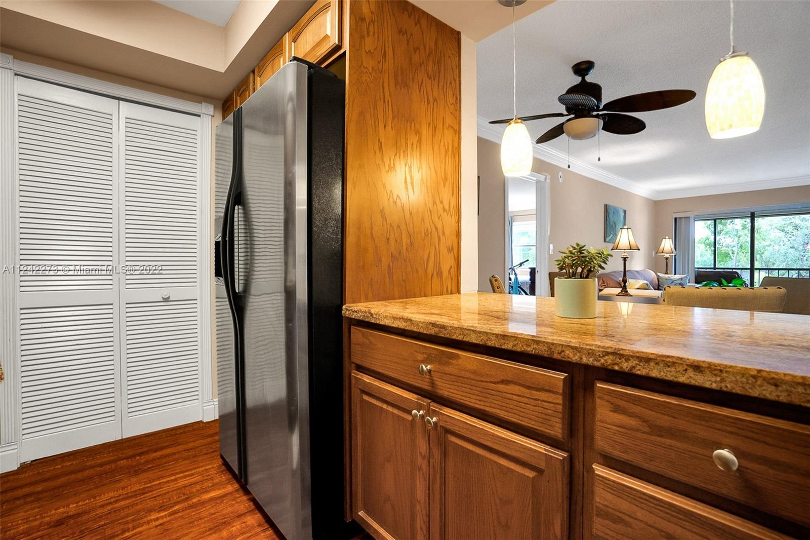 303 Racquet Club Road, Unit 307 Weston, FL 33326 - Photo 6 of 22 a kitchen with stainless steel appliances granite countertop a sink and a refrigerator