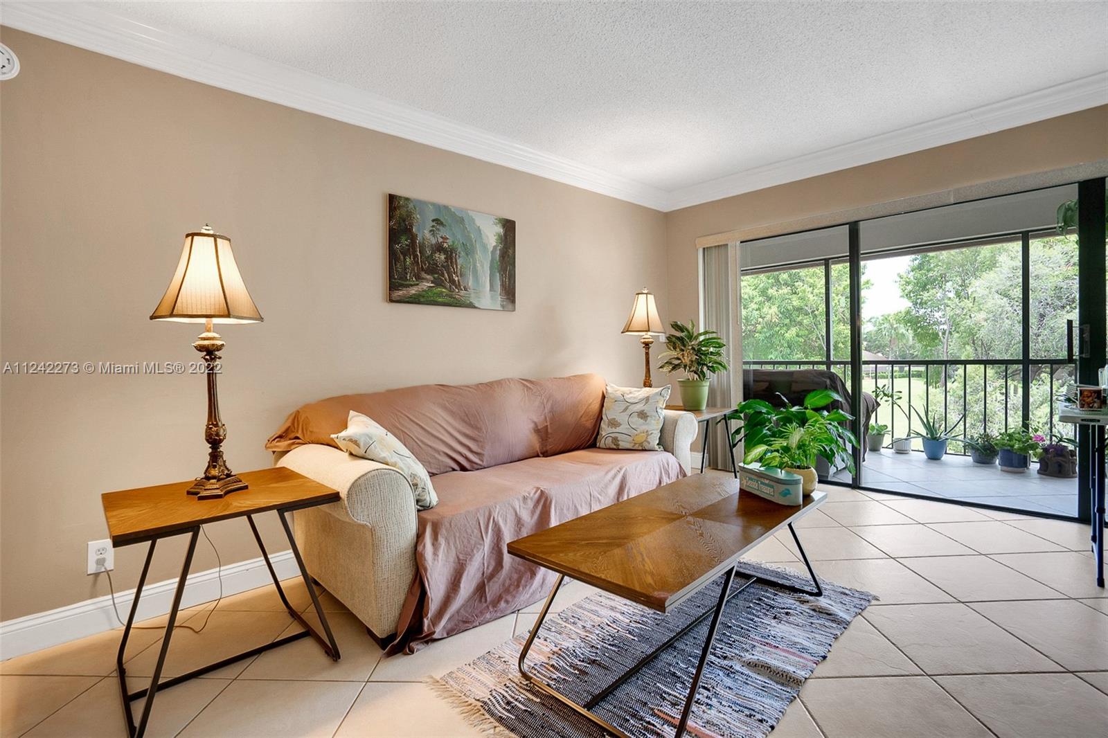 303 Racquet Club Road, Unit 307 Weston, FL 33326 - Photo 10 of 22 a living room with furniture a lamp and a potted plant