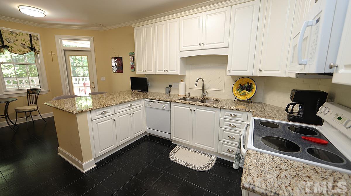 100 Northbrook Drive, Unit 203 Raleigh, NC 27609 - Photo 12 of 39 a kitchen with granite countertop a sink cabinets and window