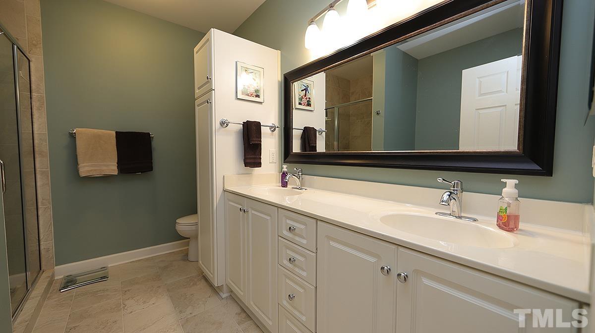 100 Northbrook Drive, Unit 203 Raleigh, NC 27609 - Photo 23 of 39 a spacious bathroom with a double vanity sink a mirror and a toilet