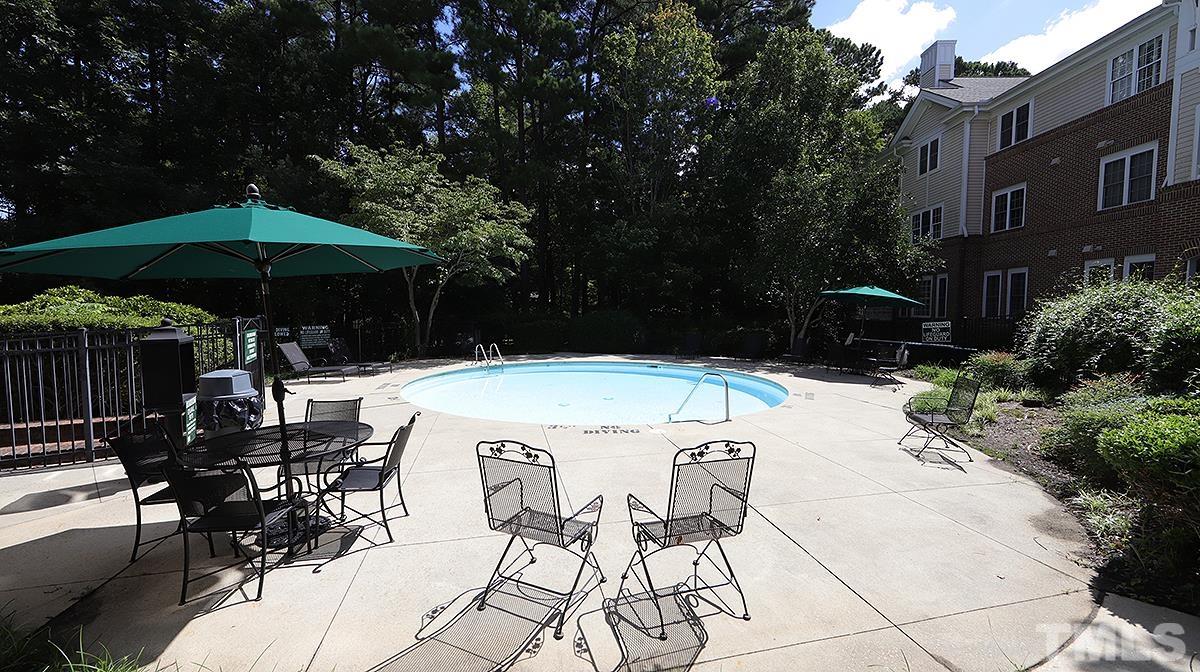 100 Northbrook Drive, Unit 203 Raleigh, NC 27609 - Photo 32 of 39 a view of backyard with table and chairs under an umbrella