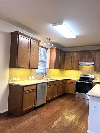 a large kitchen with stainless steel appliances granite countertop a sink and cabinets