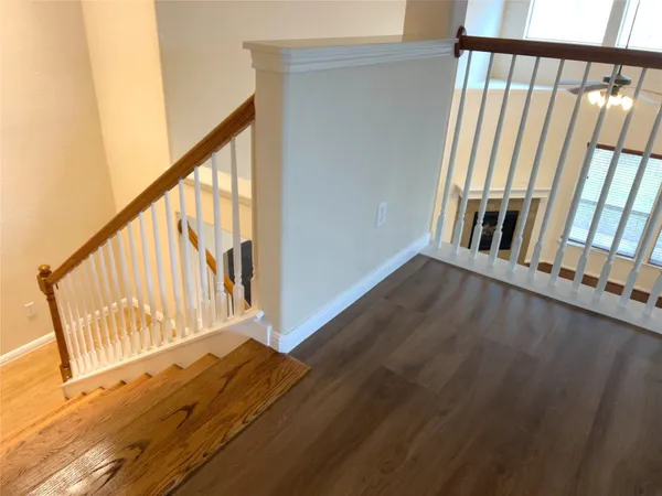 a view of an empty room with wooden floor fireplace and a window