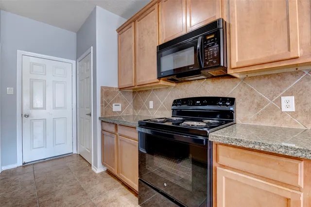 a kitchen with stainless steel appliances granite countertop a stove microwave and sink