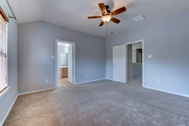 an empty room with a ceiling fan and a window
