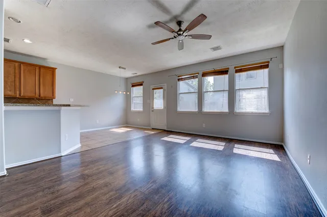 a view of an empty room with a window and wooden floor