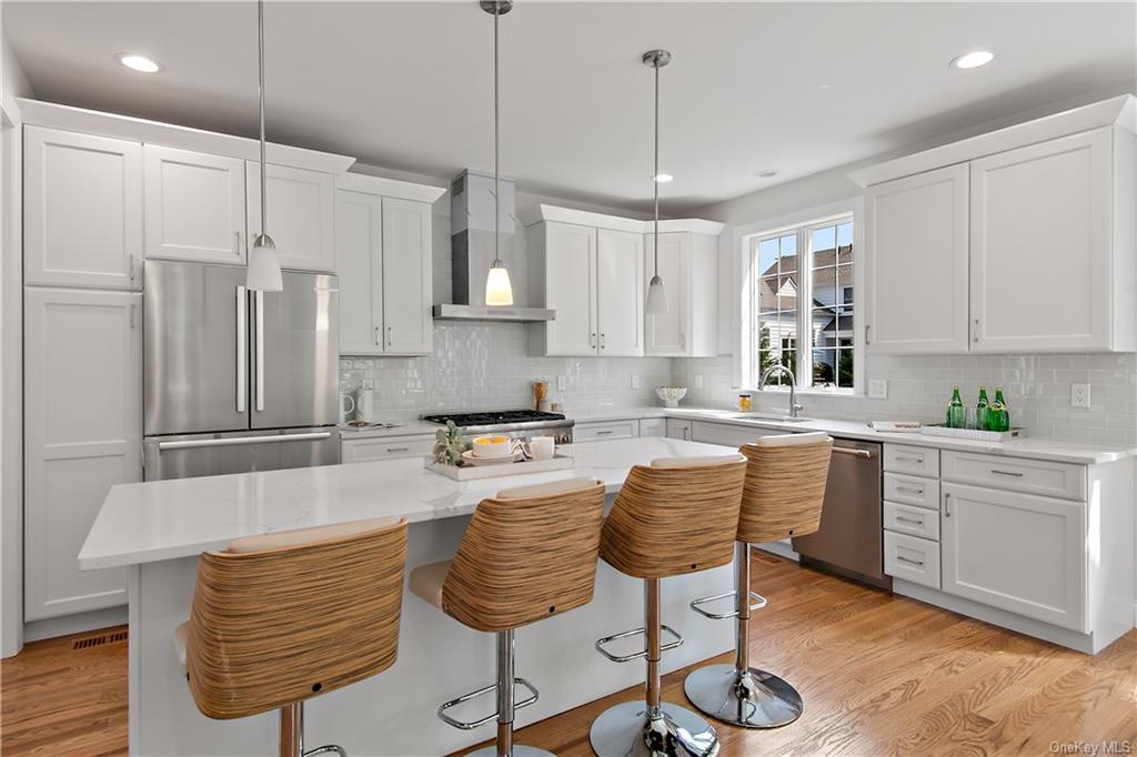 a large kitchen with granite countertop a counter space a sink stainless steel appliances and cabinets