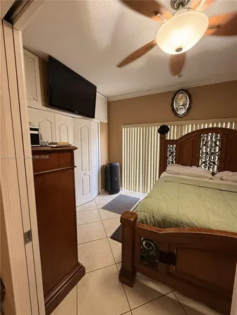 a bedroom with a bed and a flat tv screen on the dresser