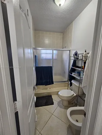 a bathroom with a sink a toilet a mirror and shower