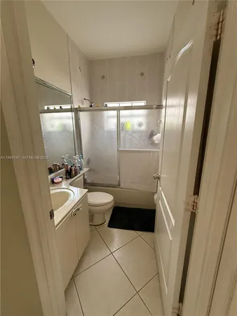 a bathroom with a sink a toilet a tub and shower