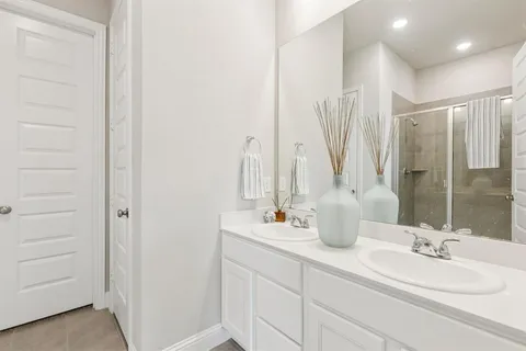 a bathroom with double vanity sink and a mirror