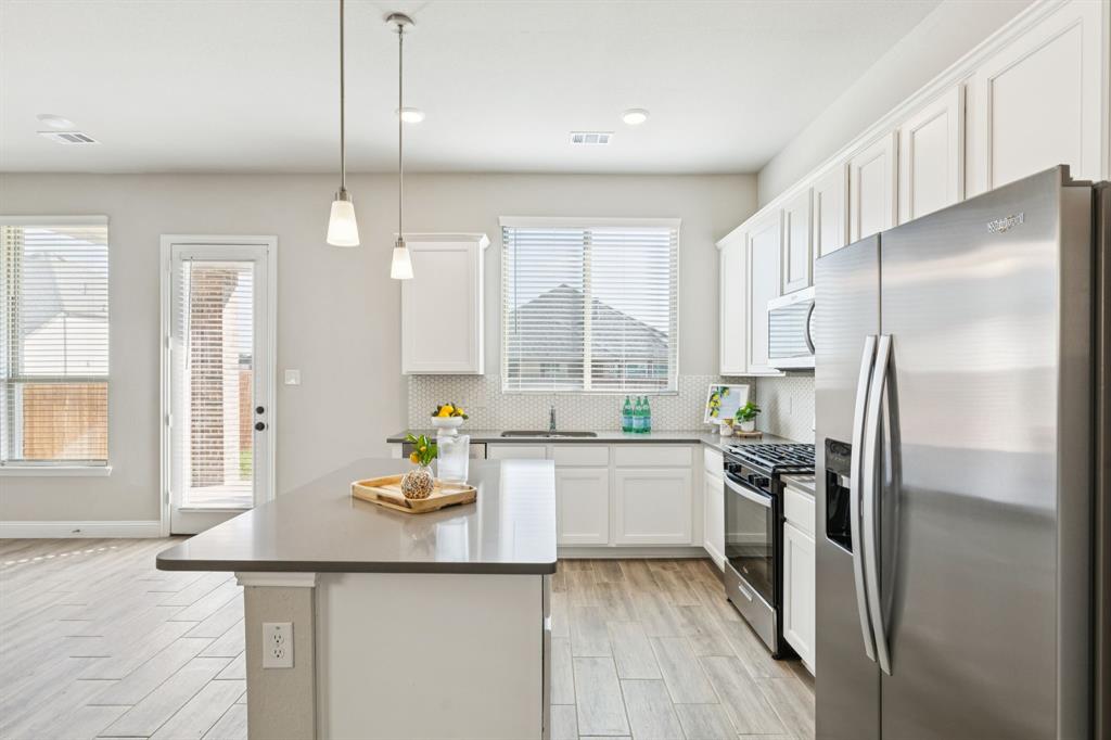 1222 El Sol Boulevard Sherman, TX 75090 - Photo 10 of 39 a kitchen with stainless steel appliances granite countertop a refrigerator a sink a stove and white cabinets with wooden floor