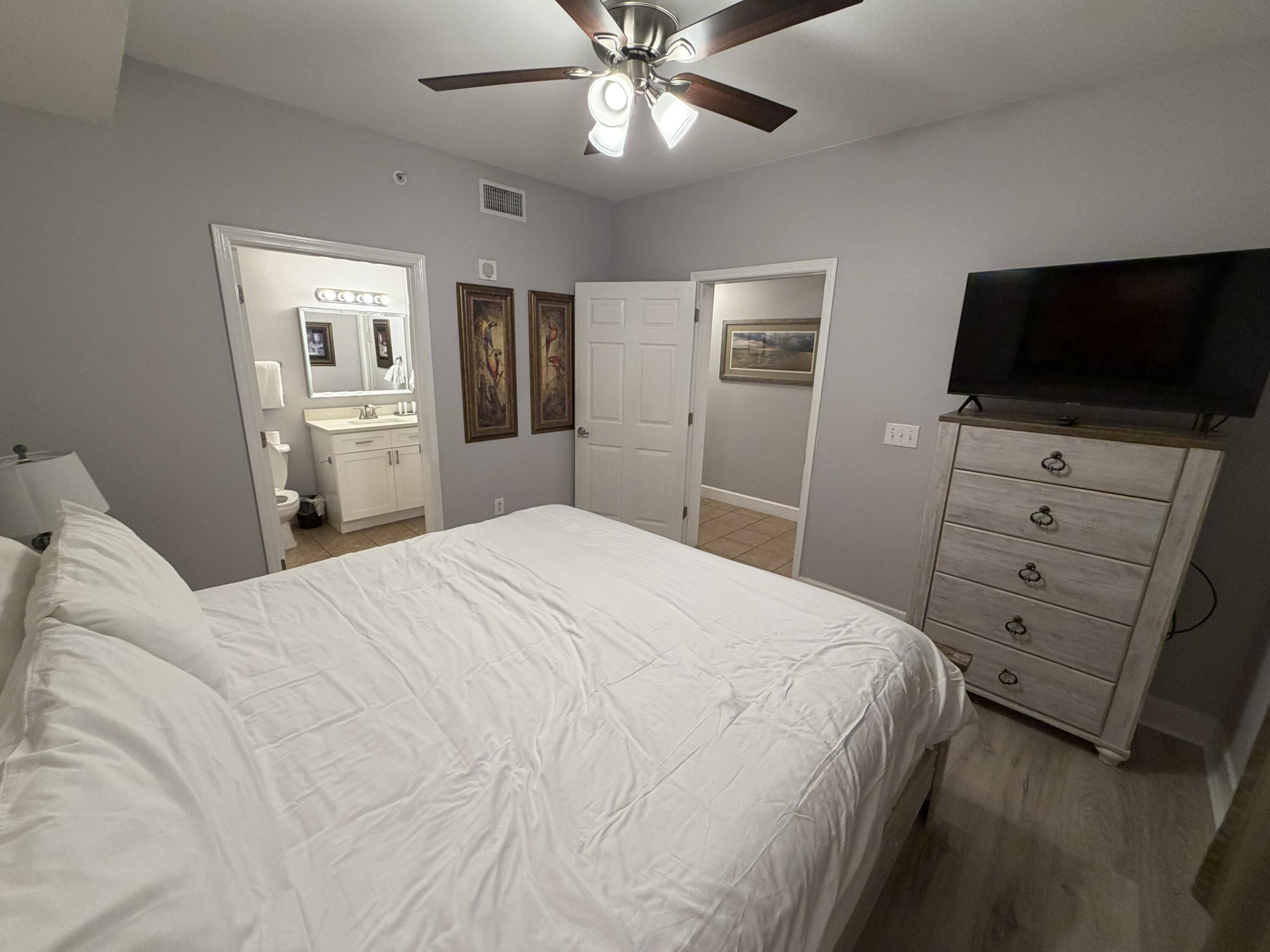 16819 Front Beach Road, Unit 2214 Panama City Beach, FL 32413 - Photo 13 of 49 a bedroom with a bed and a flat screen tv