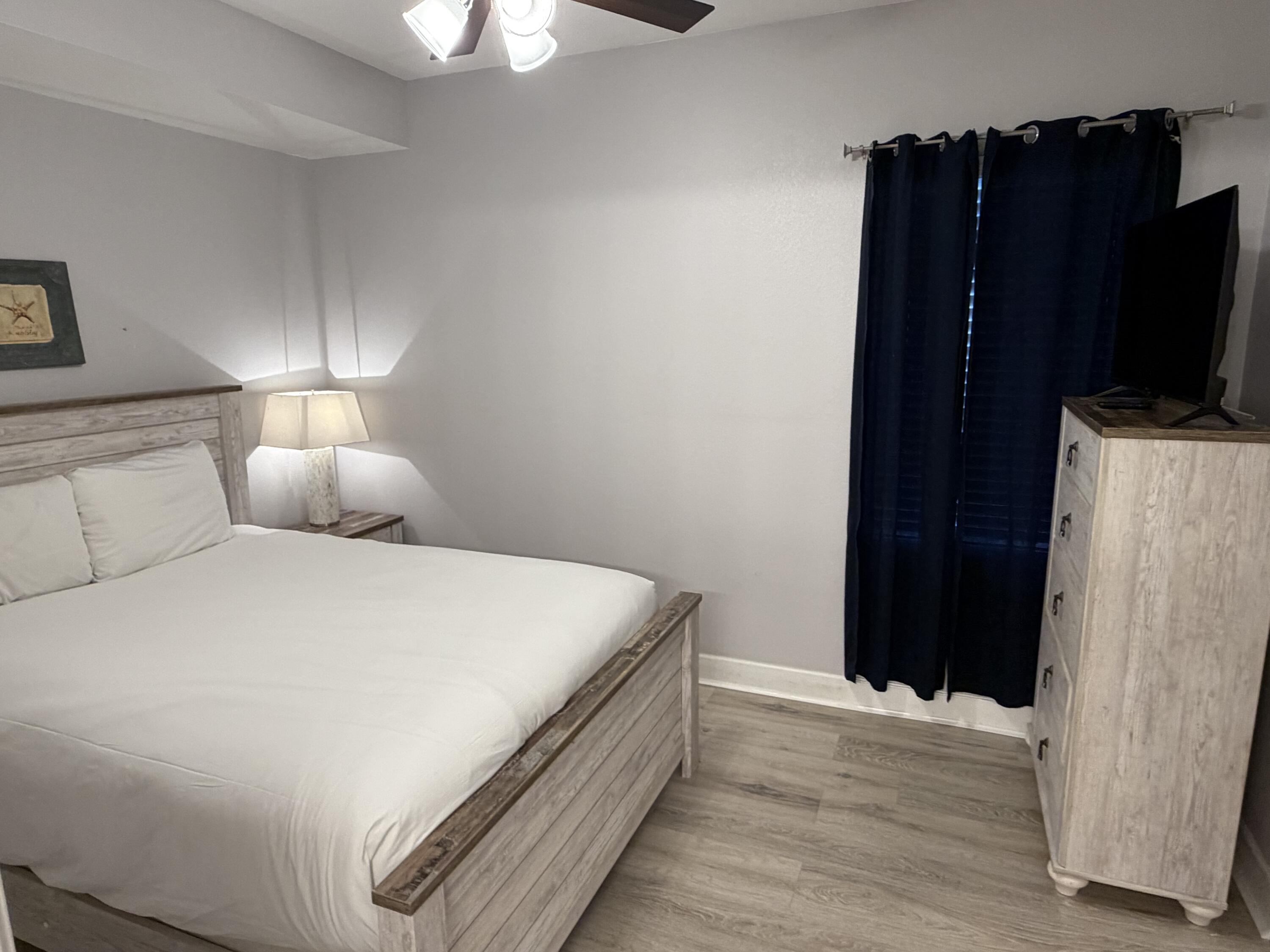 16819 Front Beach Road, Unit 2214 Panama City Beach, FL 32413 - Photo 18 of 49 a bedroom with a bed and a flat tv screen on a dresser