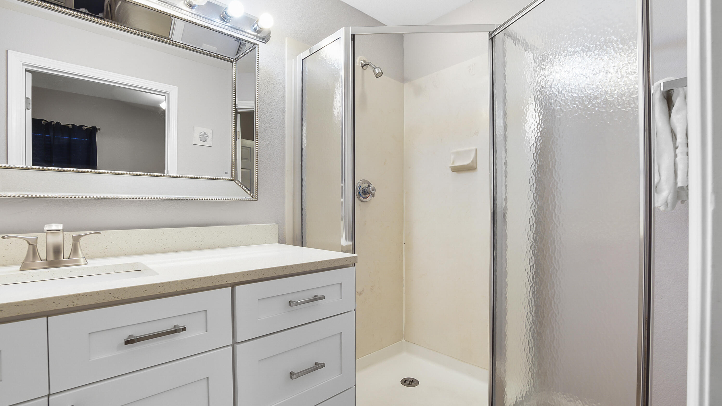 16819 Front Beach Road, Unit 2214 Panama City Beach, FL 32413 - Photo 20 of 49 a bathroom with a shower sink and mirror
