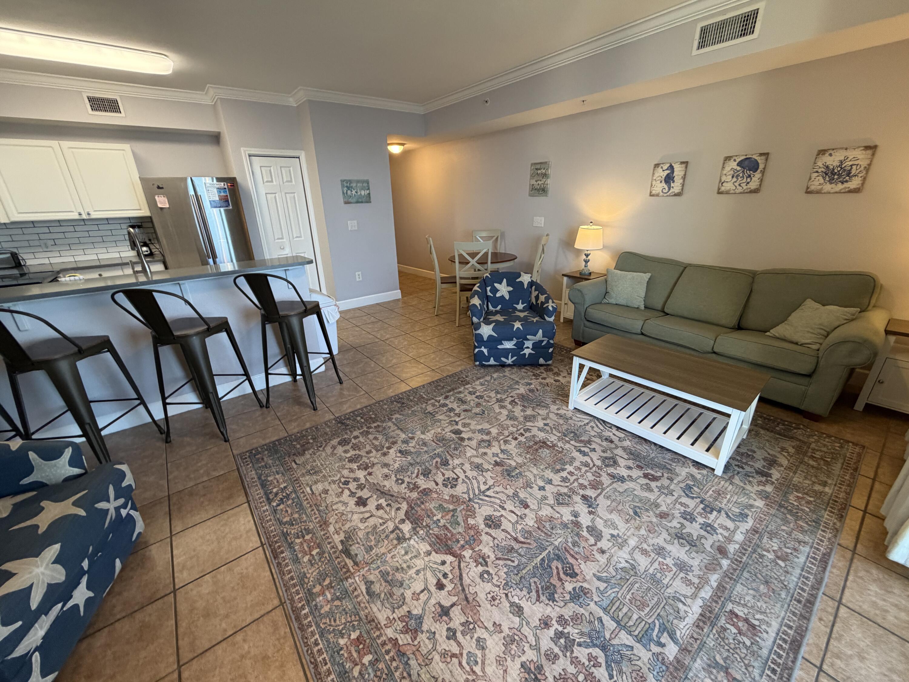 16819 Front Beach Road, Unit 2214 Panama City Beach, FL 32413 - Photo 2 of 49 a living room with furniture and wooden floor