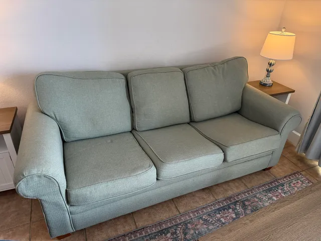 a kitchen with a sink a counter top space and living room filled with furniture