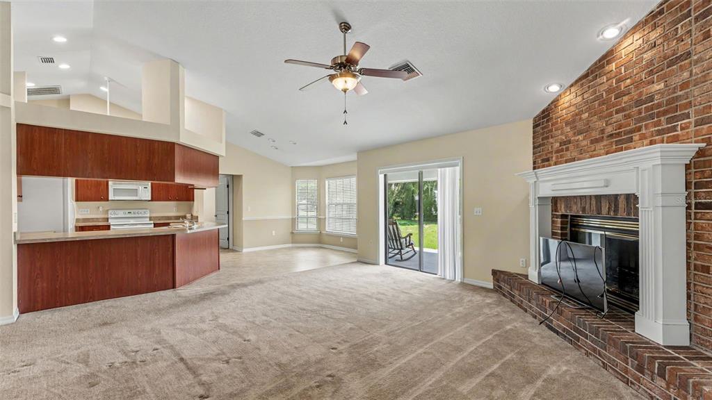 8525 North Campbell Road Lakeland, FL 33810 - Photo 36 of 45 a open kitchen with granite countertop a stove top oven a sink and dishwasher a fireplace with wooden floor