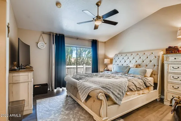 a bedroom with a bed next to a window with a chandelier