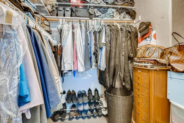 a view of walk in closet with clothes and shoes