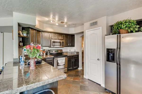 a kitchen with kitchen island a counter top space appliances and cabinets